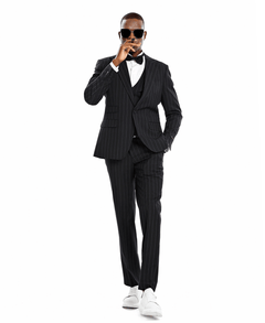 A man wearing a 3-piece suit with a bowtie. Black suit with white pinstripes.
