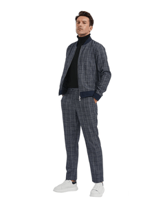 A man with his hand in his pocket. Wearing a matching Navy Blue Colored Tracksuit. A glen plaid pattern on the 2-piece matching suit. Activewear